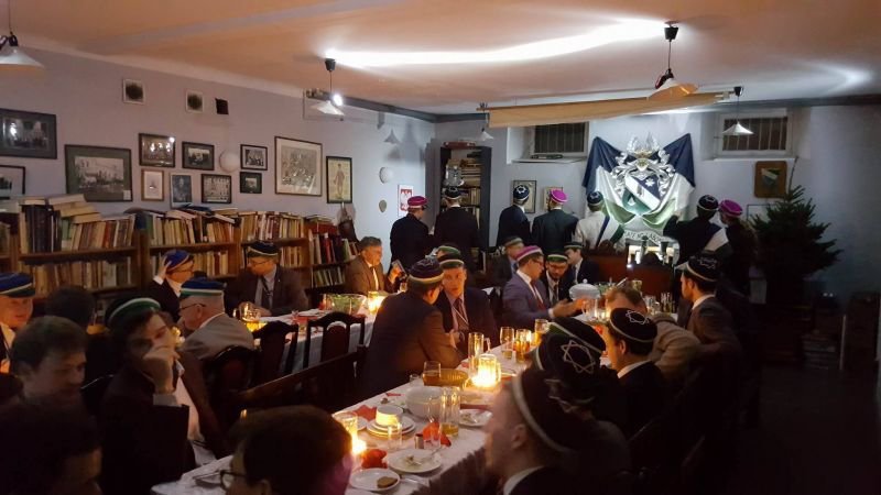 Uczestnicy spotkania wigilijnego przy stole zastawionym potrawami
