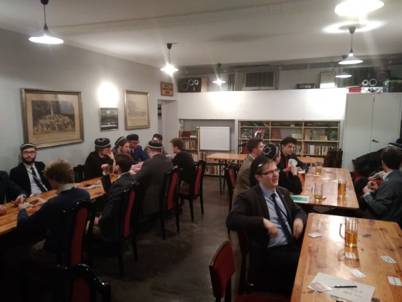 Uczestnicy spotkania grający w brydża przy stole