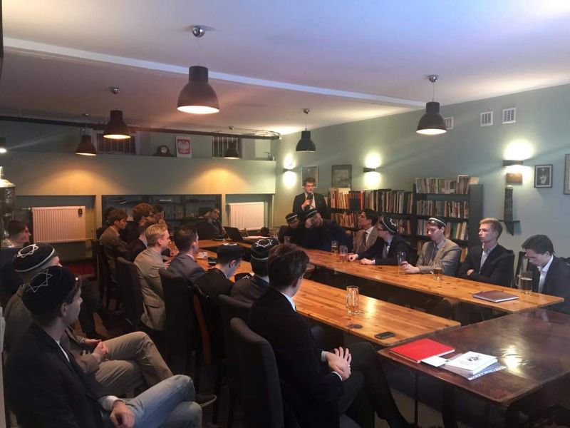 Prelegent przy tablicy podczas wykładu na kwaterze korporacji